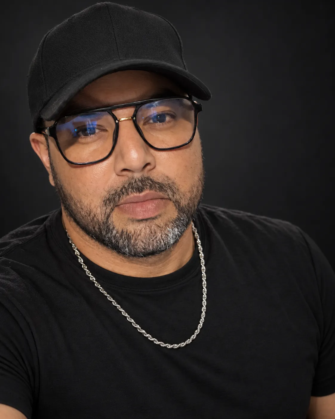 José Alejandro con lentes y gorra negra